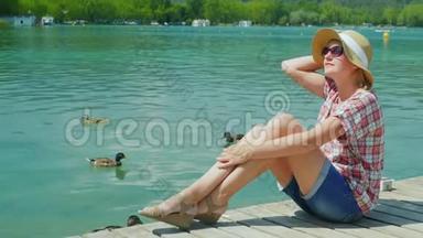 一位女游客在鸭子游泳的湖边<strong>度假</strong>。 西班牙<strong>度假</strong>村